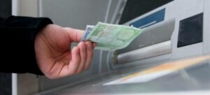 Un hombre saca dinero de un cajero